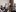 Group of people conversing in a meeting room in an office.